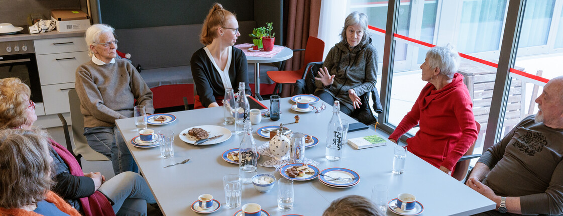 Angehörige sitzen mit Kaffee und Kuchen bei einem Angehörigencafé zusammen.