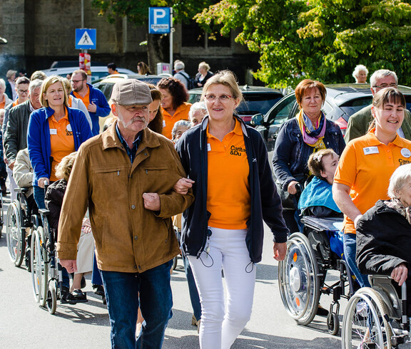 Gäste marschieren die Straße entlang