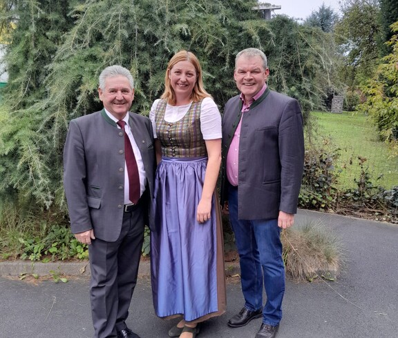 Bürgermeister Josef Niggas, Caritas-Direktorin Nora Tödtling-Musenbichler und Hausleiter Josef Url stehen lächelnd nebeneinander. Im Hintergrund ist eine gepflegte Grünanlage mit üppiger Bepflanzung zu sehen.