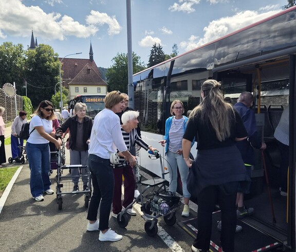Die Bewohnerinnen des Pflegewohnhauses starteten mit dem Bus zum Café Hinterberg, wobei mehrere Personen mit Rollstuhl oder Rollator mithilfe von Mitarbeiterinnen und Freiwilligen sicher in den Bus einstiegen.