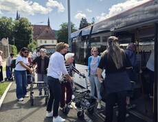 Die Bewohnerinnen des Pflegewohnhauses starteten mit dem Bus zum Café Hinterberg, wobei mehrere Personen mit Rollstuhl oder Rollator mithilfe von Mitarbeiterinnen und Freiwilligen sicher in den Bus einstiegen.
