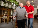 Ein Pfleger stützt einen lachenden Bewohner im Caritas Pflegewohnhaus
