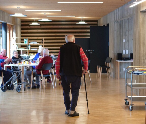 Das Bild zeigt einen gemeinsamen Aufenthaltsbereich mit mehreren Tagesgäste im Tageszentrum, in dem ältere Menschen in einer hellen, barrierefreien Umgebung Zeit miteinander verbringen.