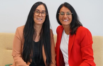2 Frauen sitzen auf einem Sofa