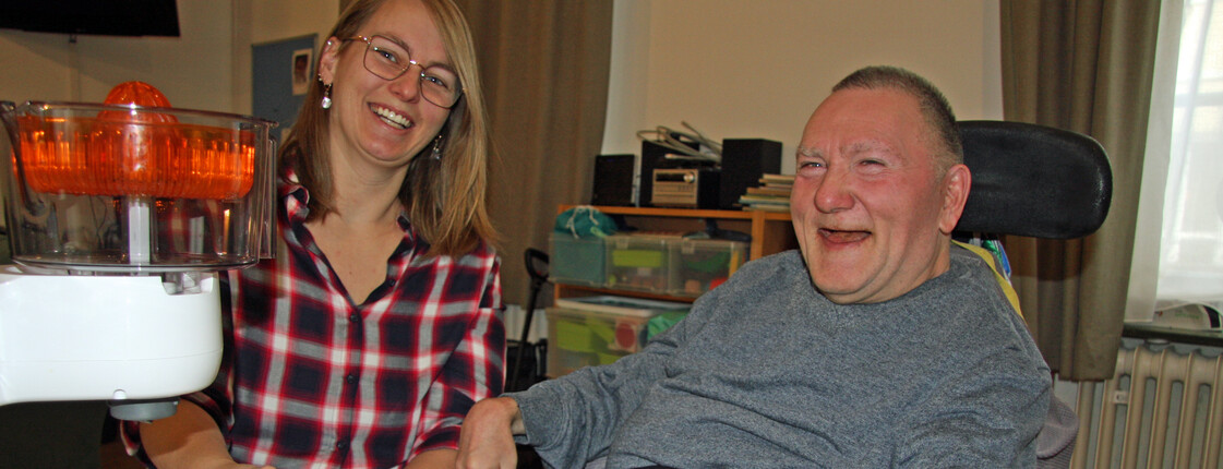 Frau links im Bild, Mann im Rollstuhl rechts im Bild