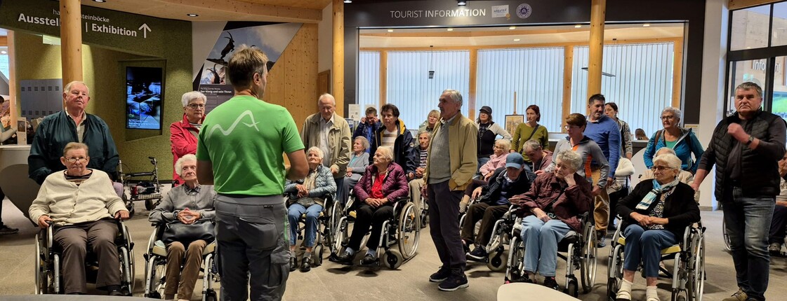 Gruppe älterer Menschen bei Einführung durch einen Mitarbeitenden im Haus der Steinböcke