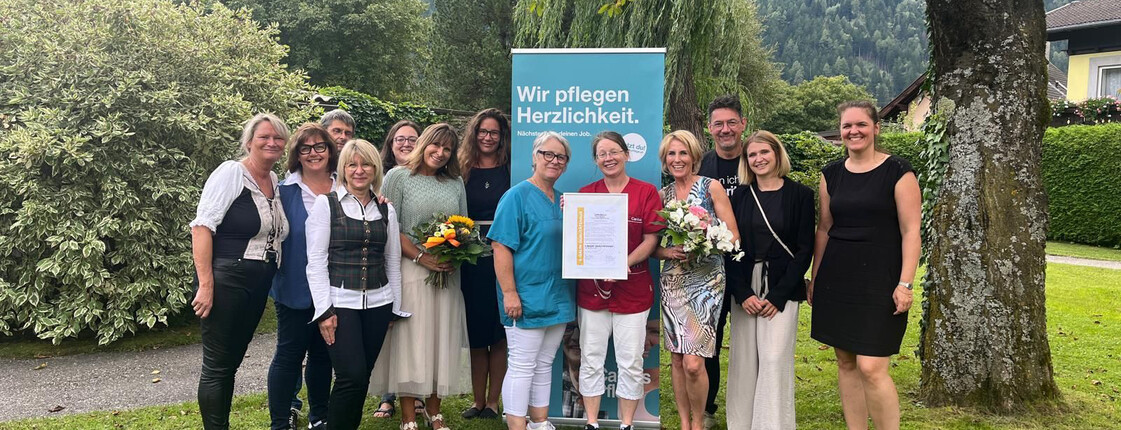 Mitarbeiter*innen des Pflegewohnhauses präsentieren das Zertifikat E-Qalin für das Haus.