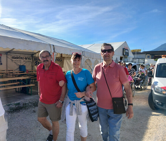 Bewohner*innen und Begleitpersonen gehen gemeinsam über das Gelände des Bleiburger Wiesenmarkts.