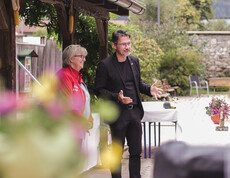 Zwei Personen sprechen bei der Eröffnung des Herbstfestes im Garten des Caritas St. Hemma-Hauses.