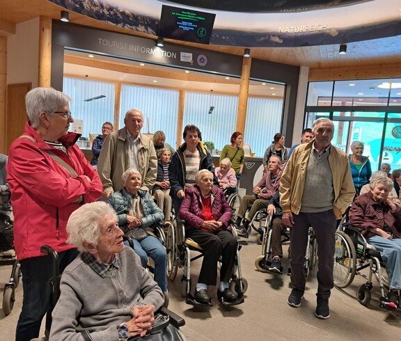 Senior*innen mit Begleitpersonen im Foyer des Hauses der Steinböcke