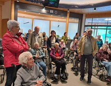 Senior*innen mit Begleitpersonen im Foyer des Hauses der Steinböcke