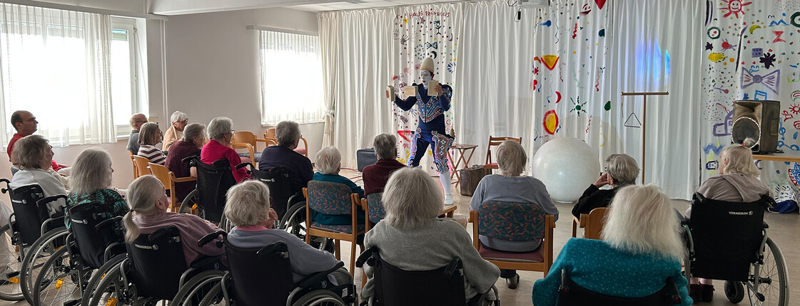 Bewohner*innen verfolgen eine Clown- und Artistikshow in Haus Franziskus.
