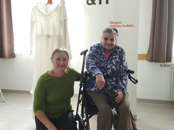 Zwei Personen im Pflegewohnhaus Gregorhof neben einem ausgestellten Kleid beim Erinnerungscafé in Bad Eisenkappel.