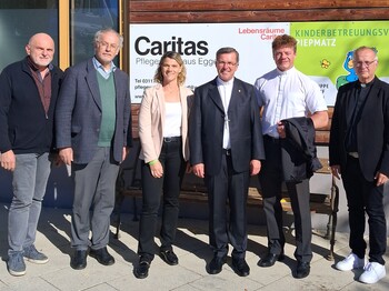 Gruppenfoto vor dem Eingang des Caritas Pflegewohnhauses Eggersdorf: Sechs Personen stehen vor einer Tafel mit dem Schriftzug „Caritas Pflegewohnhaus Eggersdorf“ und dem Logo des Kinderbetreuungsvereins Piepmatz.