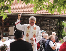 Geistlicher segnet die Gäste während der Messe beim Herbstfest im Garten des Caritas St. Hemma-Hauses.