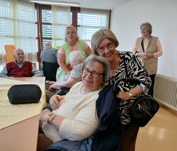 Mehrere ältere Personen und eine Begleitperson kommen bei einem gemeinsamen Nachmittag im Haus Magdalena zusammen.
