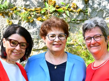 Drei ältere Frauen mit Brille schauen frontal in die Kamera