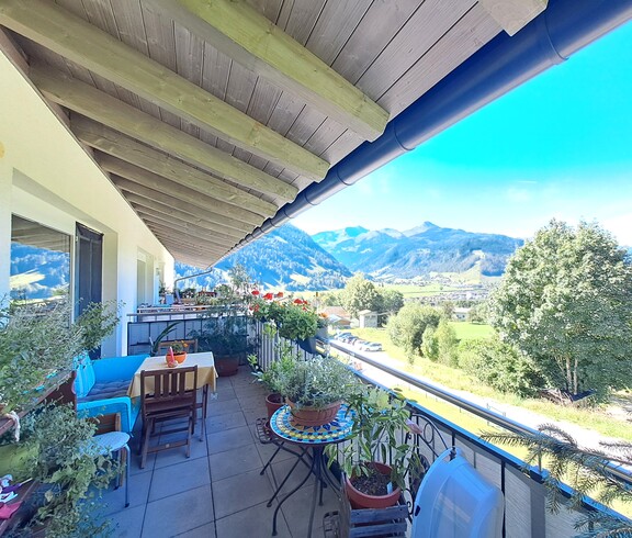 Ein Balkon mit Blumen und Blick ins Grüne