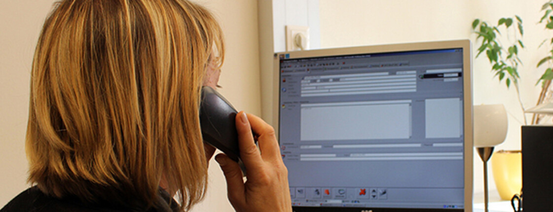 Eine Frau telefoniert in der Notrufzentrale Eine Frau telefoniert in der Notrufzentrale