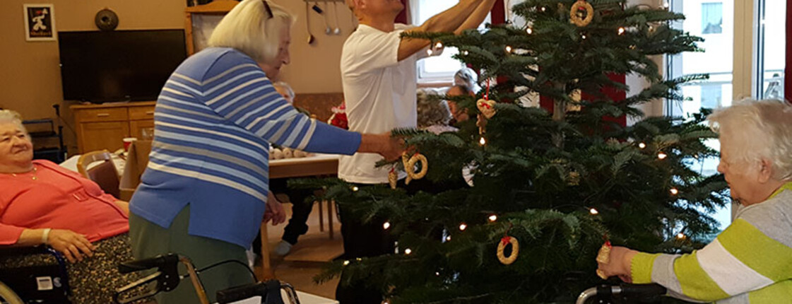 Gemeinsam wird der Christbaum geschmückt