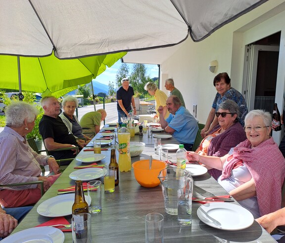 Ältere Menschen essen gemeinsam auf der Terrrasse