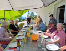 Ältere Menschen essen gemeinsam auf der Terrrasse