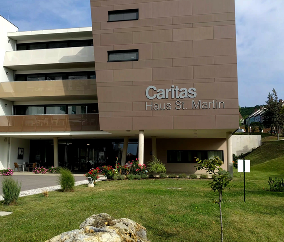 Außenaufnahme des Caritas Haus St. Martin mit Eingangsbereich und Grünfläche