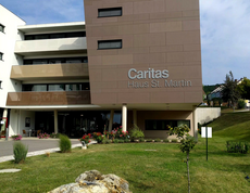 Außenaufnahme des Caritas Haus St. Martin mit Eingangsbereich und Grünfläche