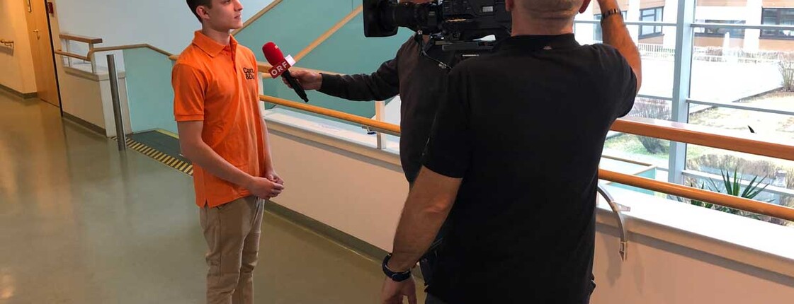 Ein Zivildiener wird von einem ORF Mann interviewt und von einem zweiten Kameraman gefilmt.