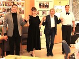 Vier Mitglieder des Künstlerkollegiums Manfred Grössler stehen nebeneinander vor den Bewohnerinnen und Bewohnern des Caritas Pflegewohnhauses Graz-Straßgang. Sie halten sich an den Händen, lächeln und verbeugen sich gemeinsam als Zeichen des Dankes für den herzlichen Applaus des Publikums.