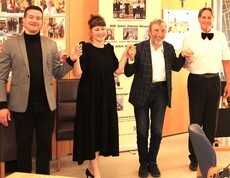 Vier Mitglieder des Künstlerkollegiums Manfred Grössler stehen nebeneinander vor den Bewohnerinnen und Bewohnern des Caritas Pflegewohnhauses Graz-Straßgang. Sie halten sich an den Händen, lächeln und verbeugen sich gemeinsam als Zeichen des Dankes für den herzlichen Applaus des Publikums.