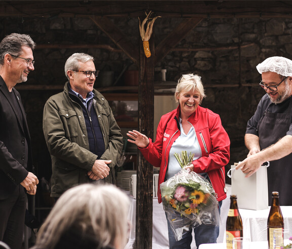 Mitarbeitende überreichen Blumen und Geschenk bei einer Verabschiedung im Caritas St. Hemma-Haus.