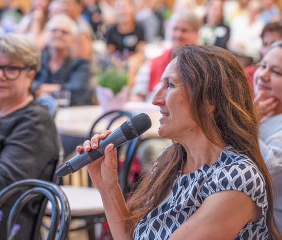 Frau spricht in Mikrofon