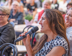 Frau spricht in Mikrofon