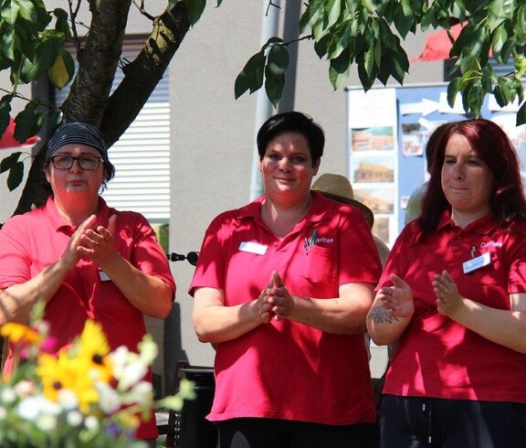 Mitarbeiterinnen des Pflegewohnhauses klatschen beim Jubiläumsfest zum 20-jährigen Bestehen zur Musik und tragen zur fröhlichen Feststimmung bei.