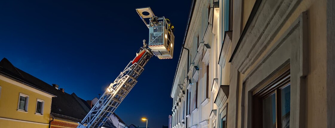 Feuerwehrfahrzeug mit ausgefahrener Drehleiter bei einer nächtlichen Feuerwehrübung am Haus Elisabeth in St. Andrä.