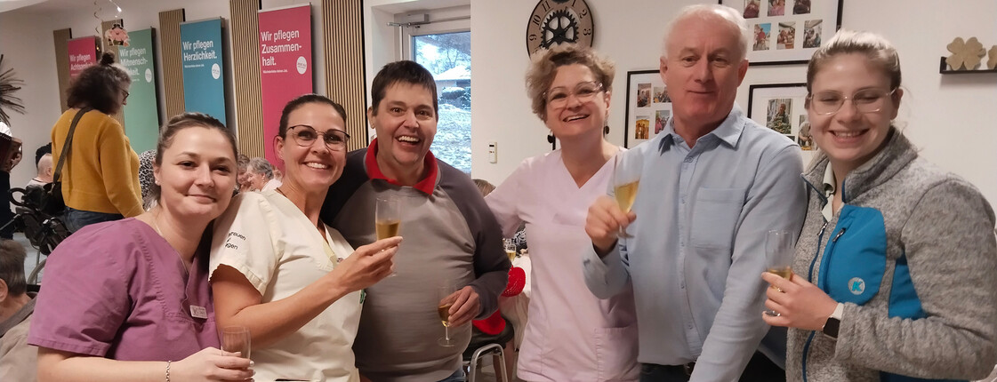 Mitarbeitende stoßen gemeinsam bei Bauernsilvester im festlichen Raum an