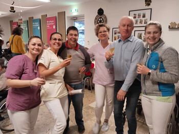 Mitarbeitende stoßen gemeinsam bei Bauernsilvester im festlichen Raum an