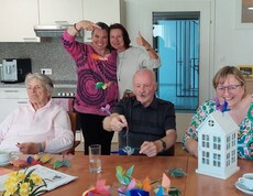 5 Menschen beim Basteln an einem Tisch