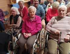 Bewohner*innen des Haus Michael sitzen im Kulturhaus Obervellach im Publikum des Theaterstücks und verfolgen die Aufführung.