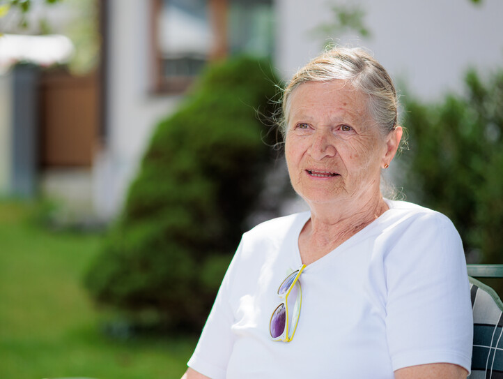 Eine junge Frau und eine Pensionistin Arm in Arm