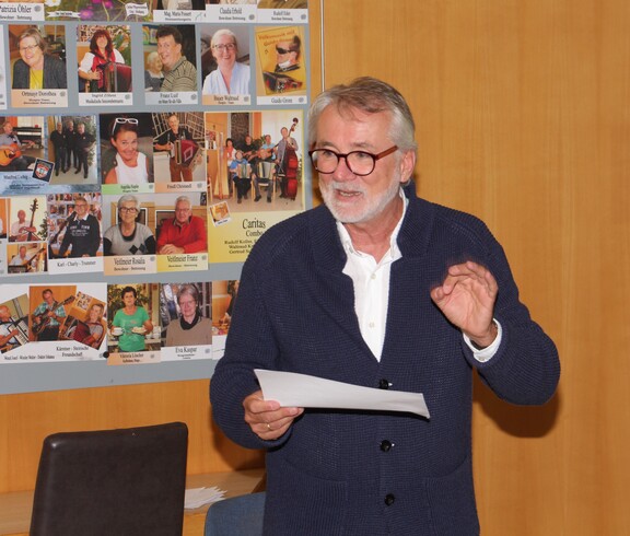Dr. med. univ. Erwin Horst Pilgram hält im Pflegewohnhaus einen Impulsvortrag vor den anwesenden Angehörigen. Er steht im Vordergrund, spricht engagiert und vermittelt seine Inhalte mit fachlicher Kompetenz