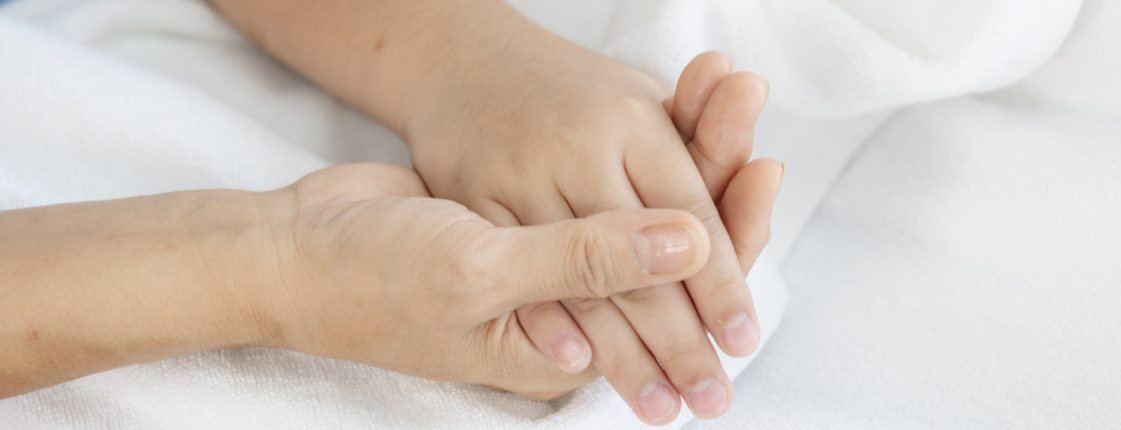 Eine Hand hält die Hand eines Kindes