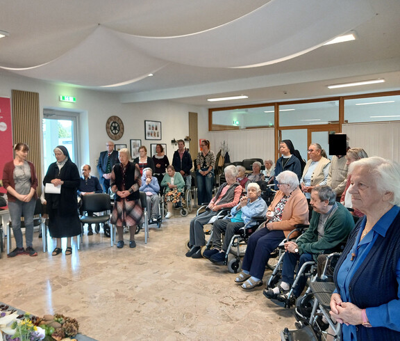 Beim Erntedank-Gottesdienst musiziert eine Gruppe neben Altar, Kerzen und herbstlich geschmückten Erntegaben.