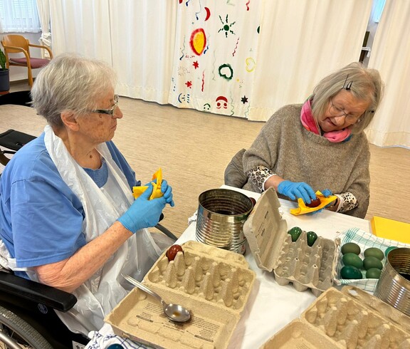 Bewohner*innen färben Ostereier.