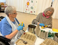 Bewohner*innen färben Ostereier.