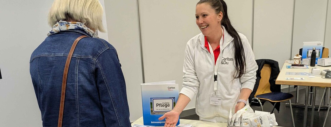 Zwei Frauen unterhalten sich an einem Informationstisch