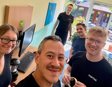 Das Team von Fortna lächelt in die Kamera. Im Hintergrund ist die abgeklebte Wand im Aufenthaltsraum des Pflegewohnhauses zu sehen.