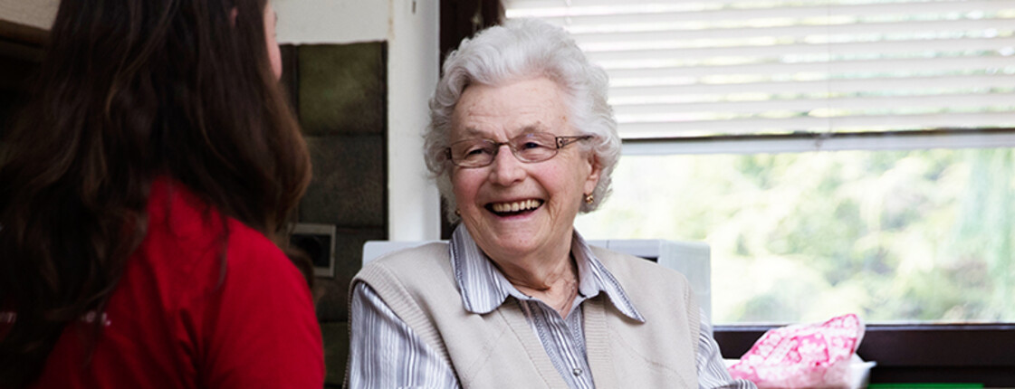 Seniorin am Küchentisch