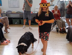 Kind mit auffälliger Brille führt Hund Emi über den Laufsteg, Publikum sitzt rundherum.